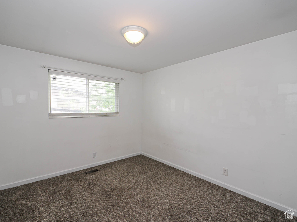 Carpeted empty room featuring baseboards