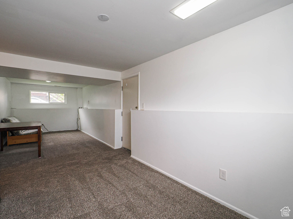 Spare room featuring carpet flooring and baseboards