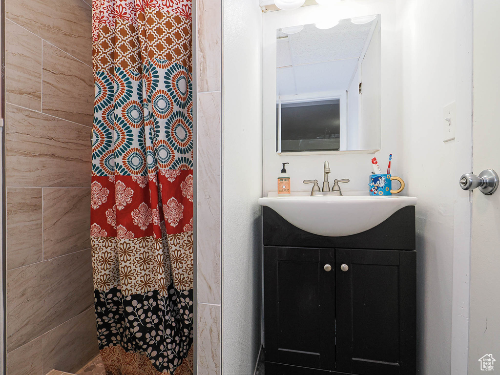 Bathroom featuring curtained shower and vanity
