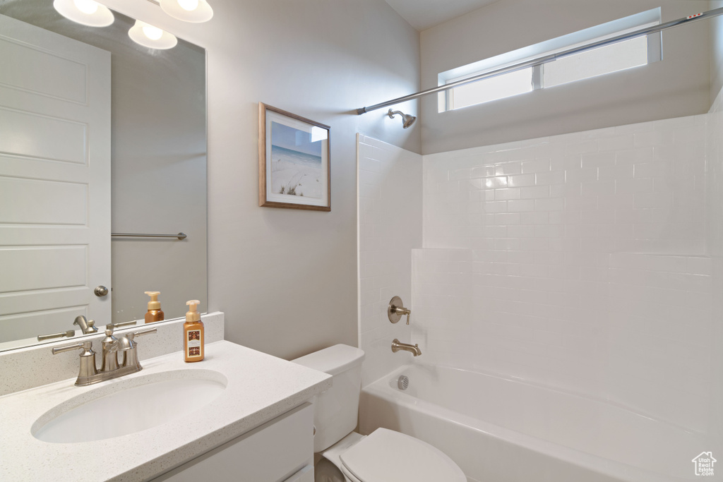 Bathroom featuring toilet, vanity, and tub / shower combination
