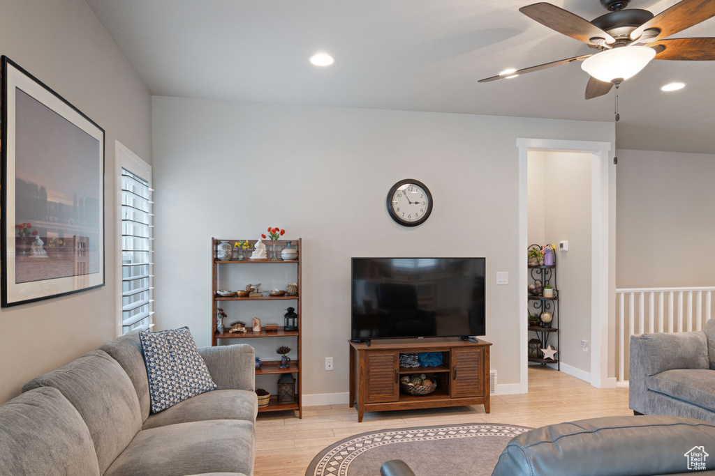 Living area with a ceiling fan, light wood finished floors, recessed lighting, and baseboards