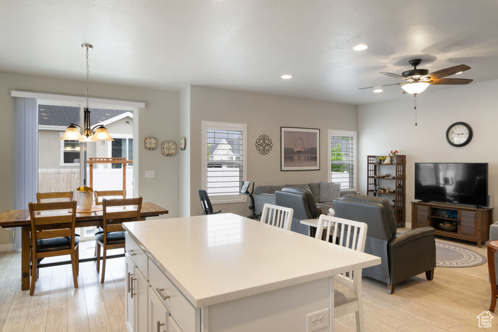 Kitchen with plenty of natural light, white cabinetry, a chandelier, light wood finished floors, and recessed lighting