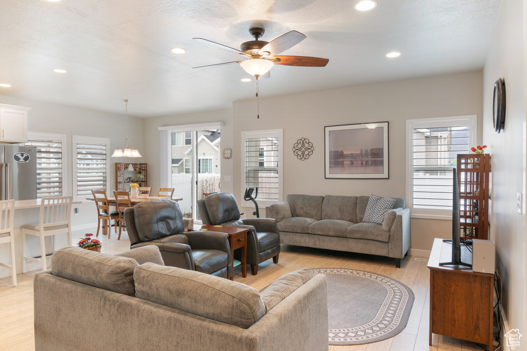 Living area with ceiling fan, recessed lighting, light wood-type flooring, and baseboards