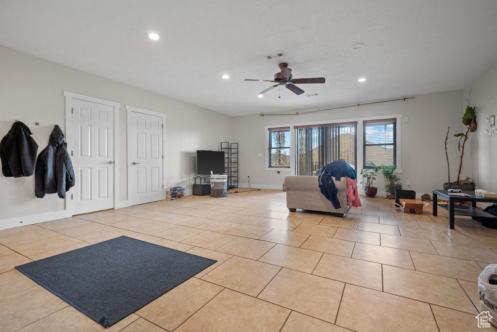 Living area with light tile patterned floors, a ceiling fan, and recessed lighting