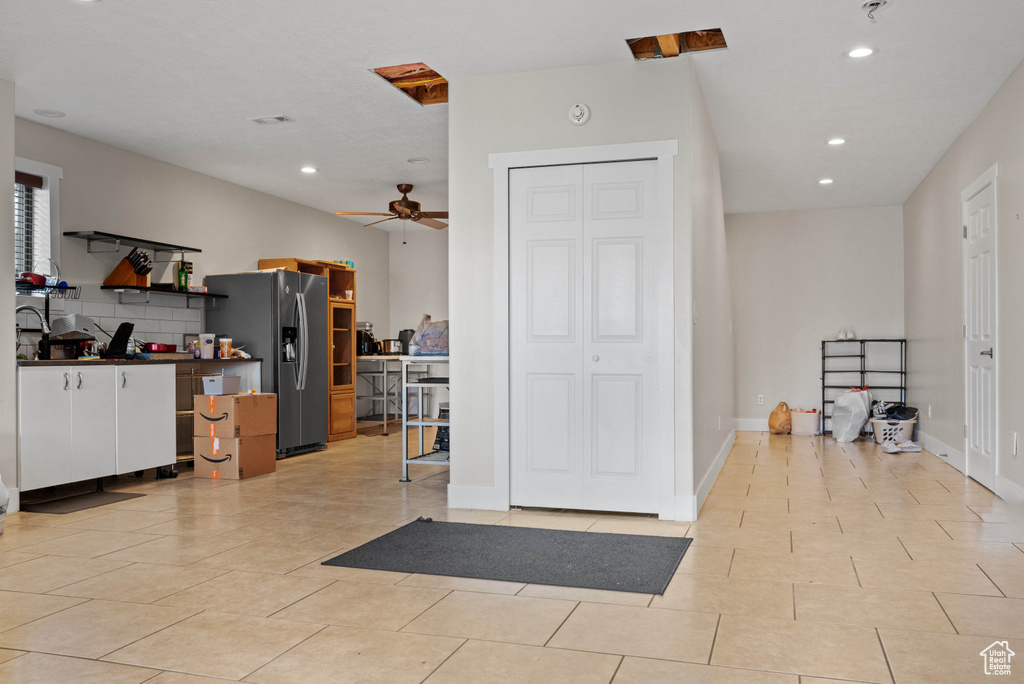 Interior space with a ceiling fan, light tile patterned floors, and recessed lighting