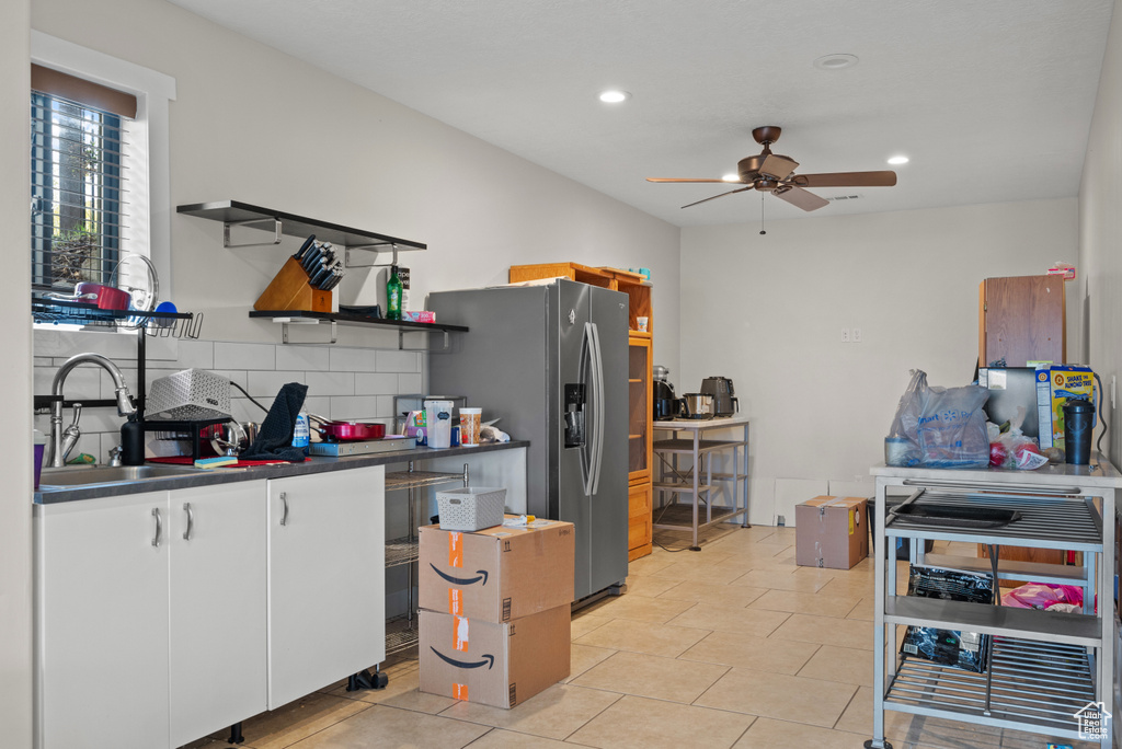 Kitchen featuring a sink, open shelves, dark countertops, white cabinets, and ceiling fan