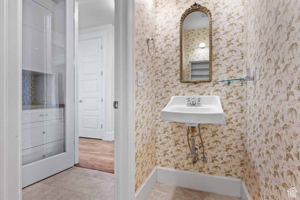Bathroom featuring tile patterned floors, baseboards, and wallpapered walls