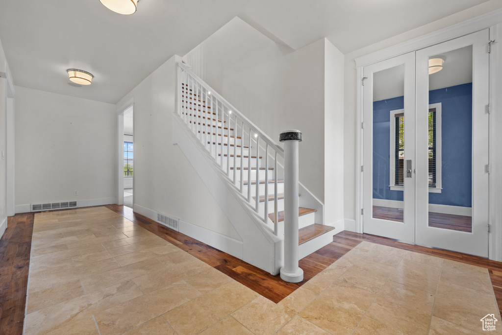 Entrance foyer featuring stairway, a healthy amount of sunlight, french doors, and visible vents