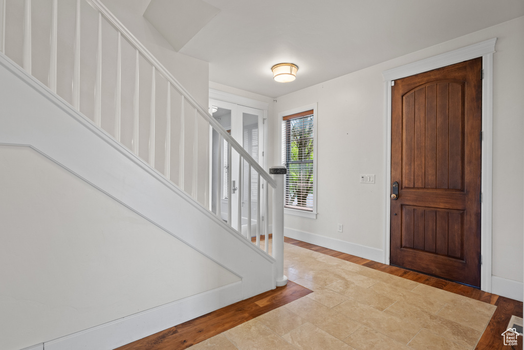 Foyer featuring baseboards, stairs, and wood finished floors