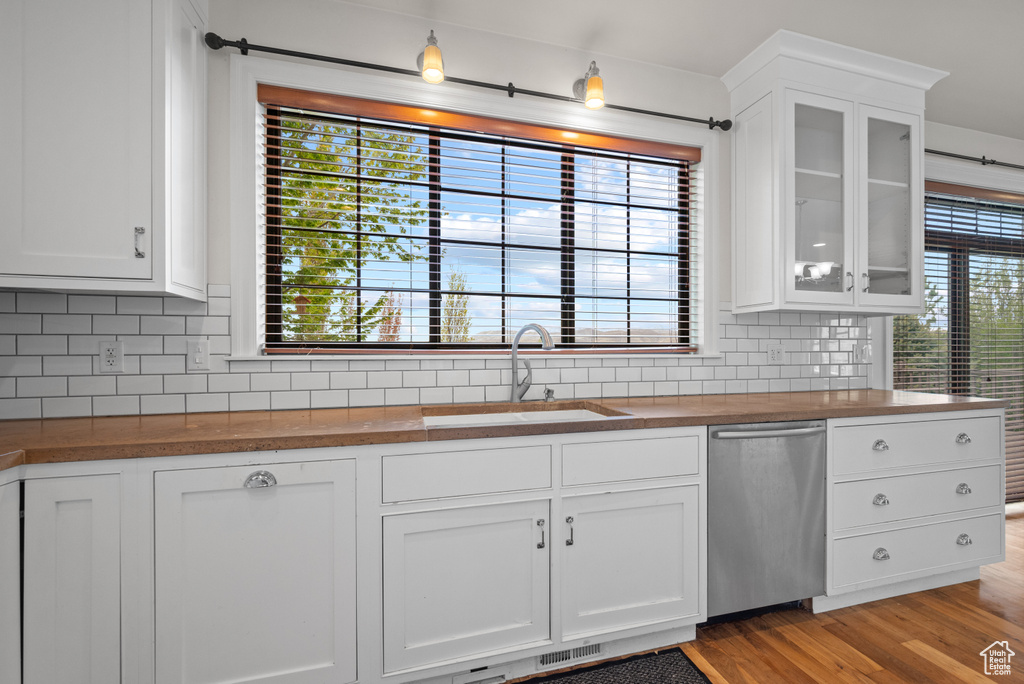 Kitchen with wood counters, tasteful backsplash, a sink, and dishwasher