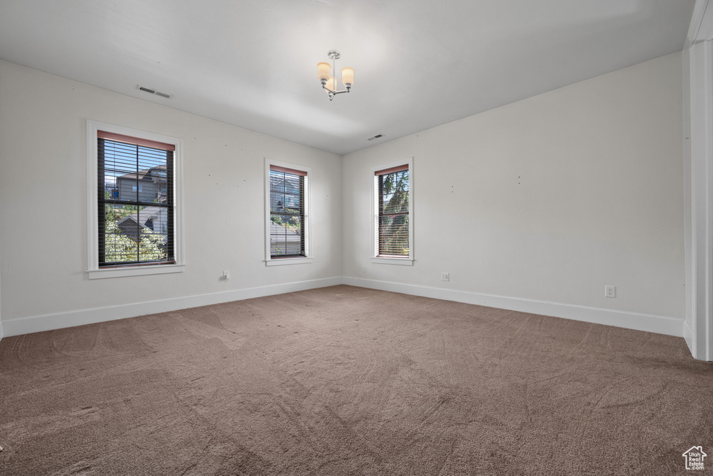 Spare room featuring baseboards, carpet flooring, and visible vents