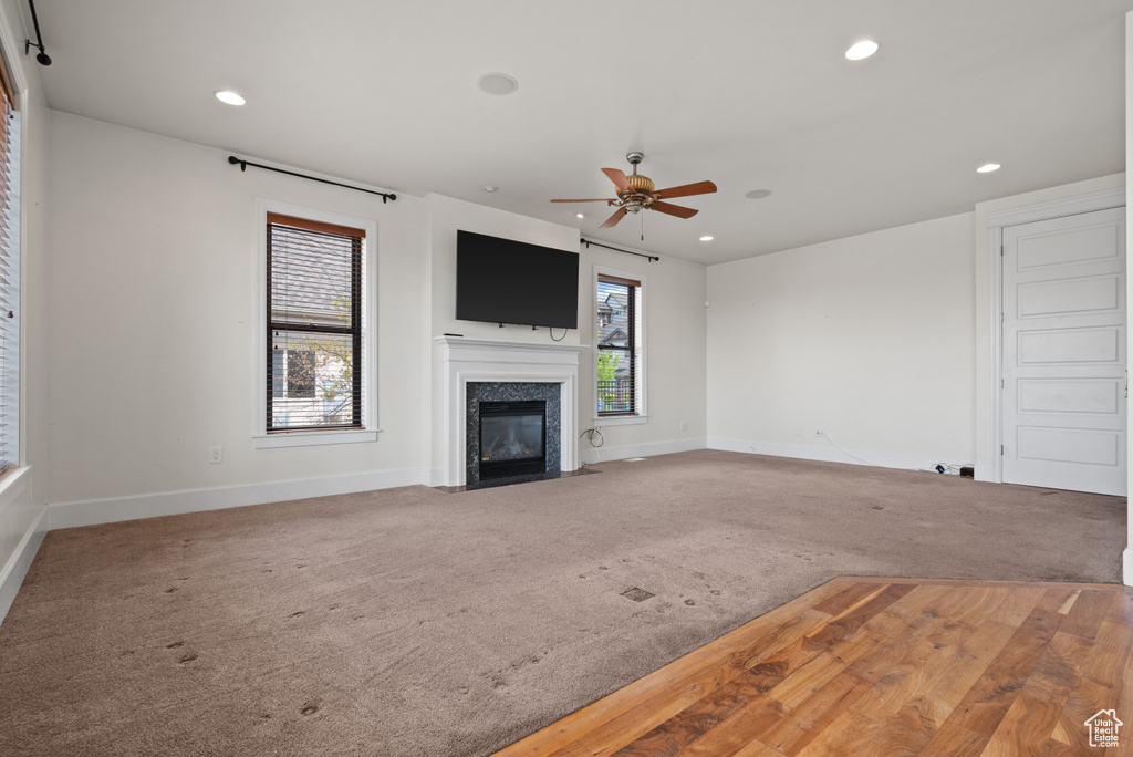 Unfurnished living room with recessed lighting, baseboards, ceiling fan, and carpet floors