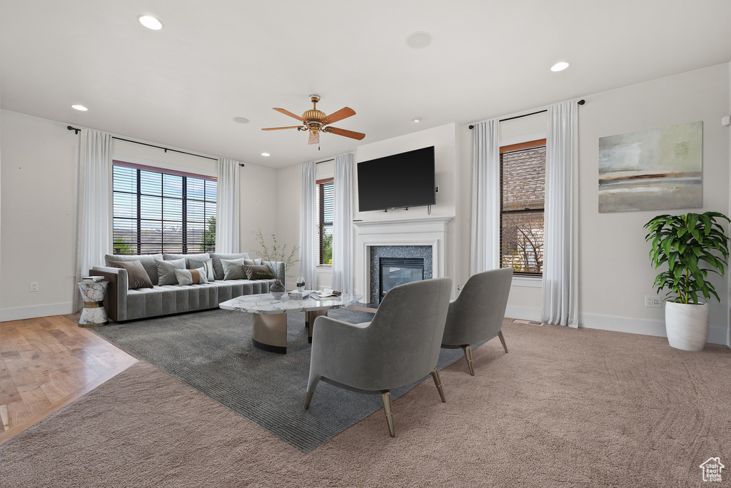 Carpeted living room featuring a ceiling fan, a glass covered fireplace, and recessed lighting
