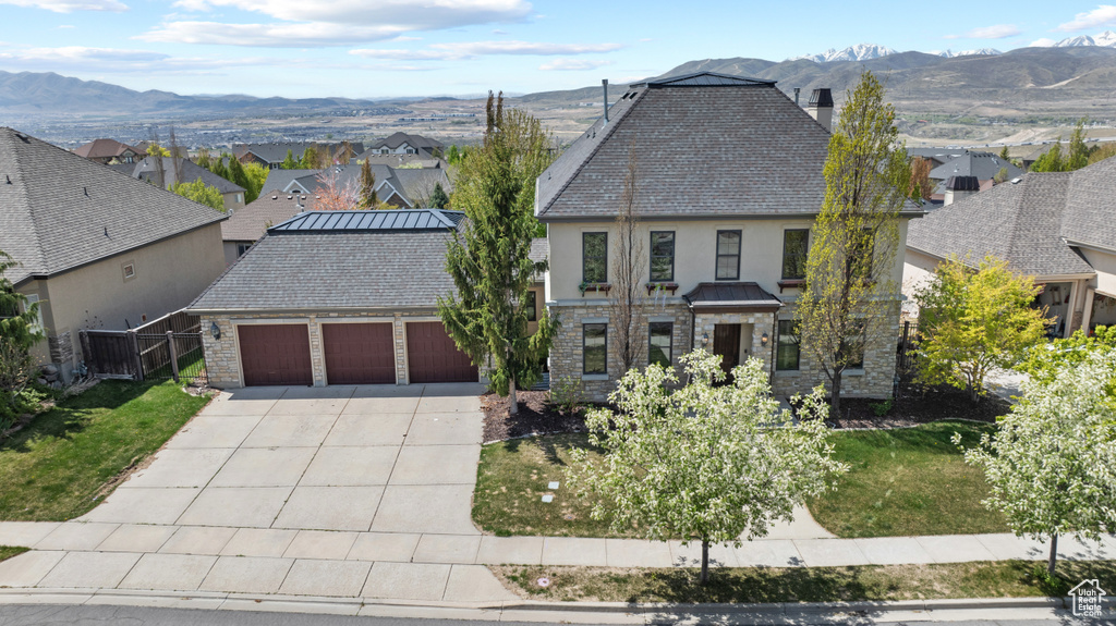 View of front of home with an attached garage, stucco siding, a residential view, and driveway