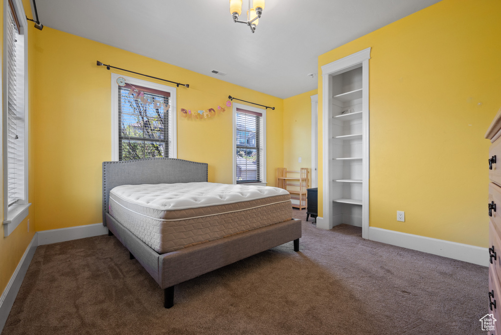 Carpeted bedroom with baseboards and visible vents