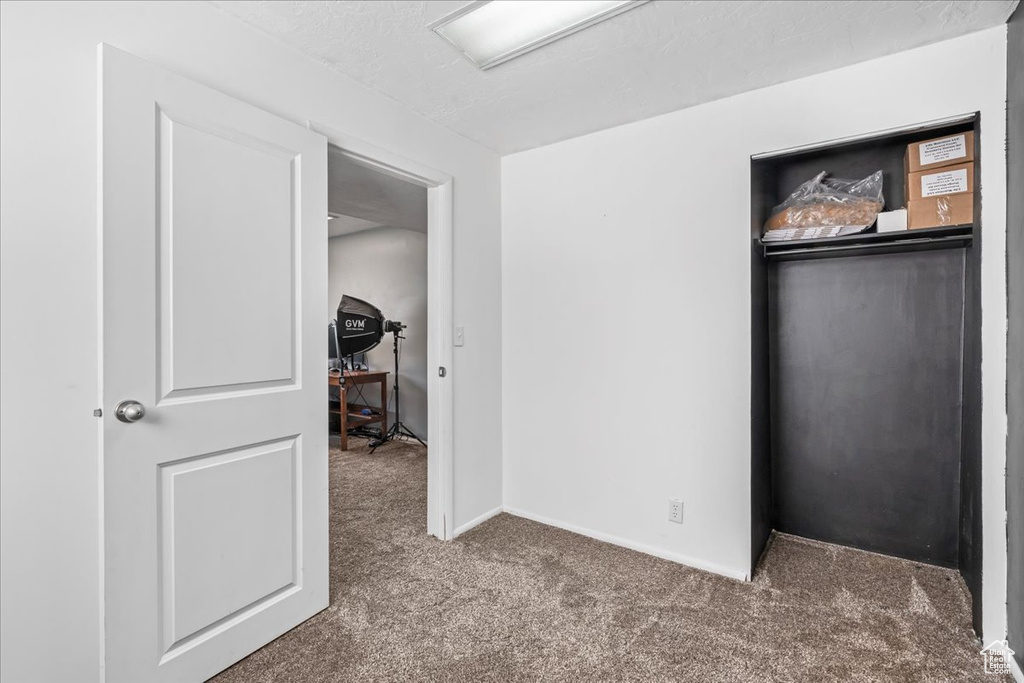 Bedroom with carpet flooring, a closet, and baseboards