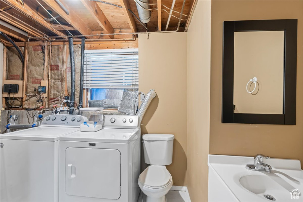 Washroom with washing machine and clothes dryer and a sink
