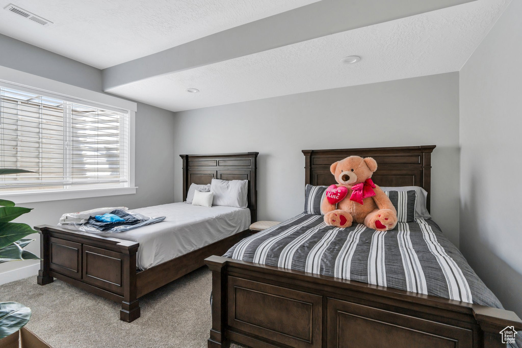 Bedroom featuring baseboards, visible vents, and light colored carpet