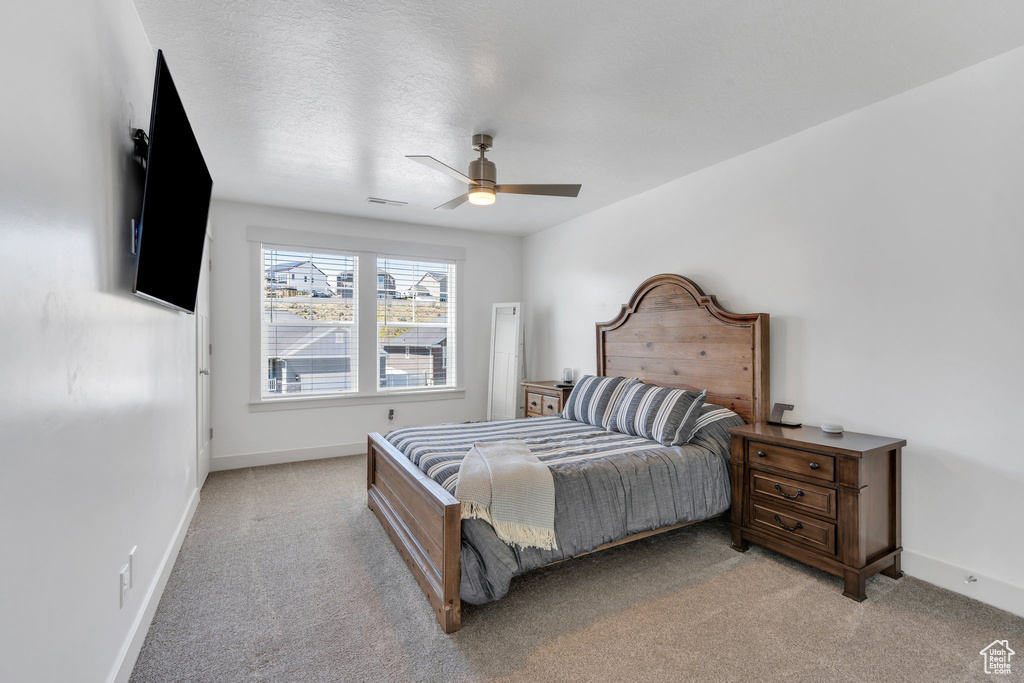 Bedroom with ceiling fan, light carpet, baseboards, and visible vents