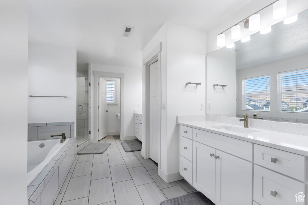 Bathroom featuring a stall shower, vanity, a bath, and plenty of natural light