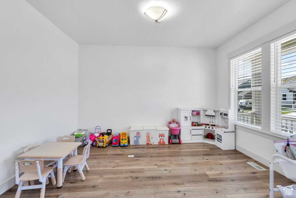 Recreation room with visible vents and wood finished floors