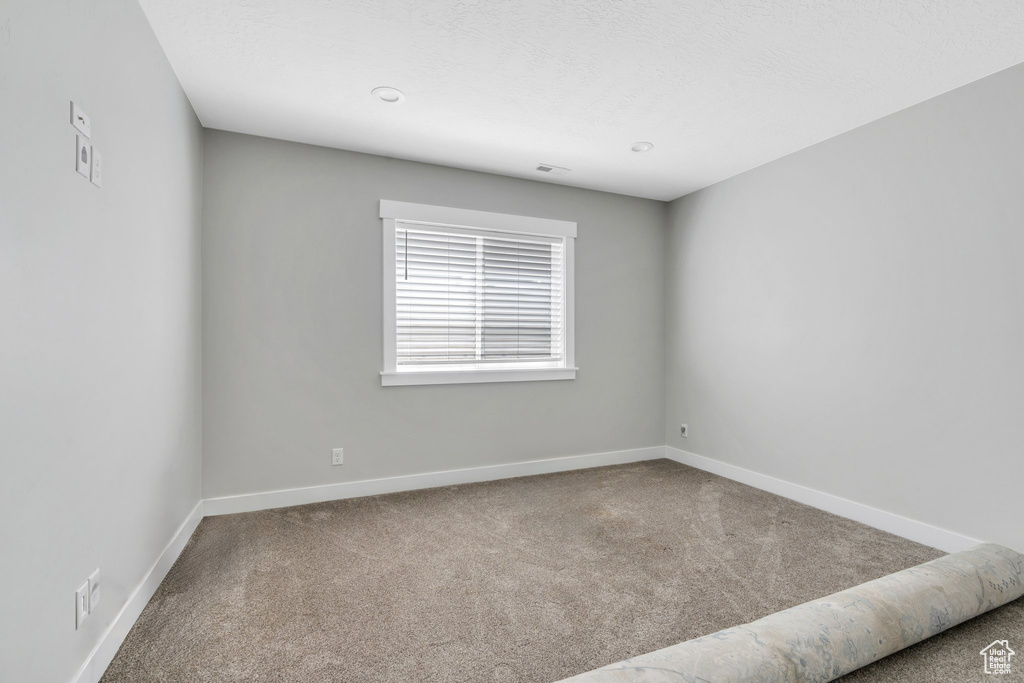 Carpeted empty room with baseboards
