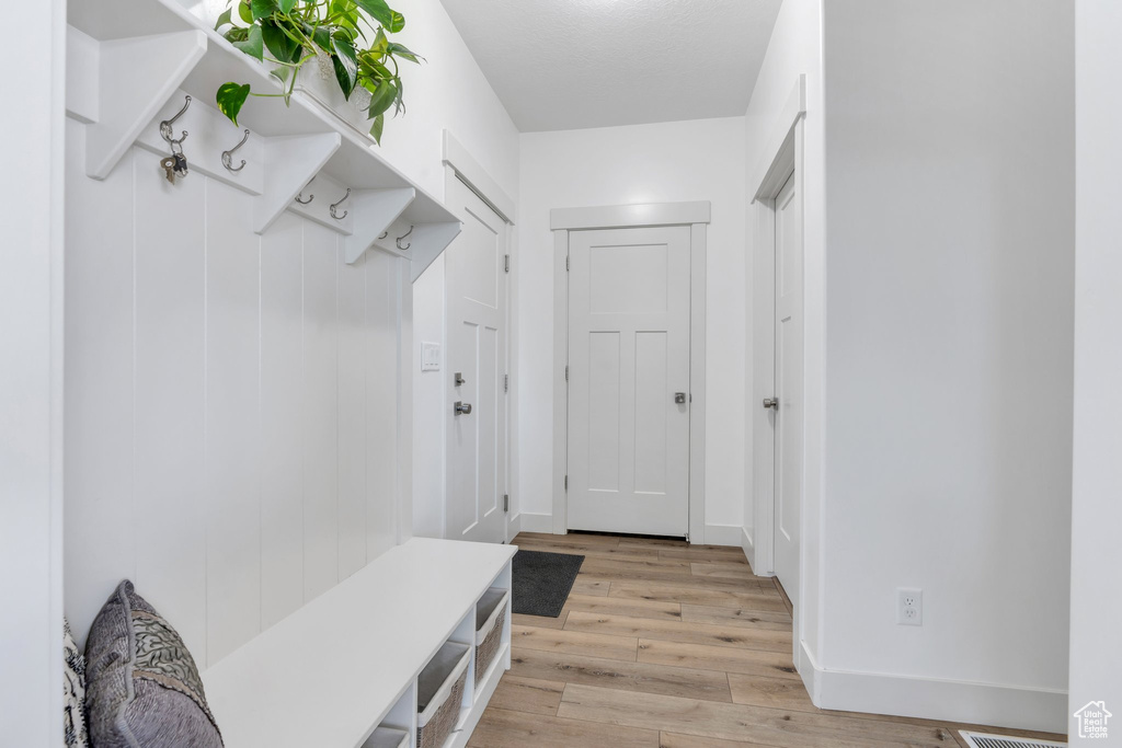 Mudroom with light wood-style flooring and baseboards