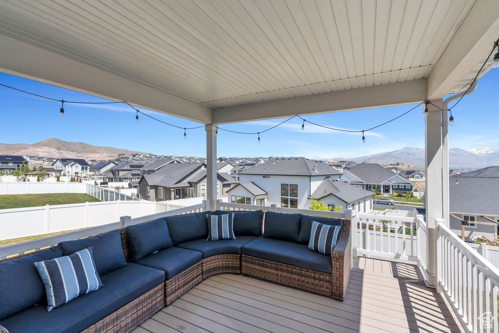 Deck with an outdoor living space, a residential view, a mountain view, and fence