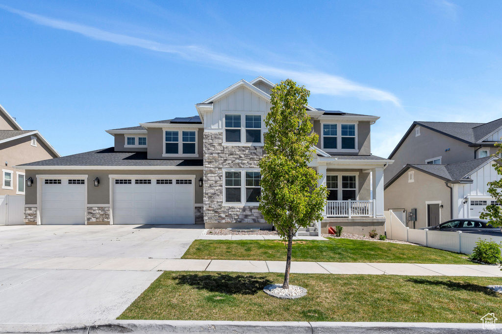 Craftsman inspired home featuring stone siding, solar panels, and covered porch