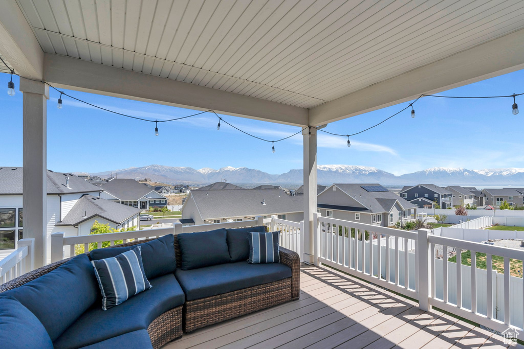 Wooden terrace featuring an outdoor hangout area, a residential view, and a mountain view
