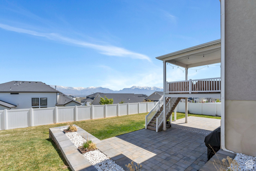 View of patio / terrace featuring stairway, a mountain view, and a fenced backyard