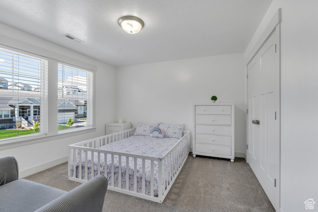 Carpeted bedroom with visible vents and baseboards
