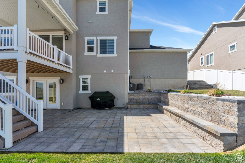 Rear view of house with stucco siding and a patio
