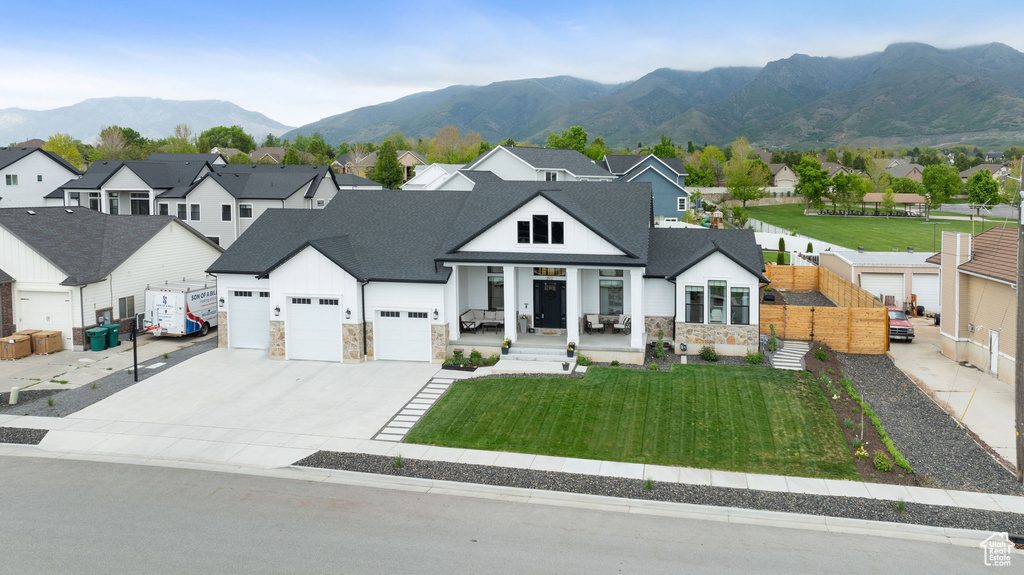 Modern farmhouse with stone siding, a residential view, concrete driveway, and an attached garage