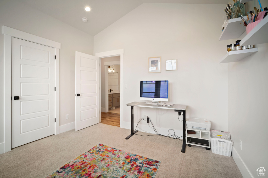 Interior space featuring high vaulted ceiling, baseboards, and carpet floors
