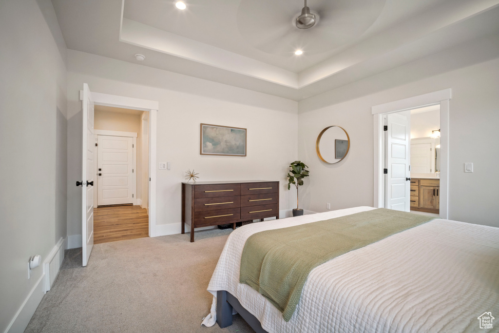 Carpeted bedroom featuring visible vents, baseboards, a raised ceiling, and recessed lighting