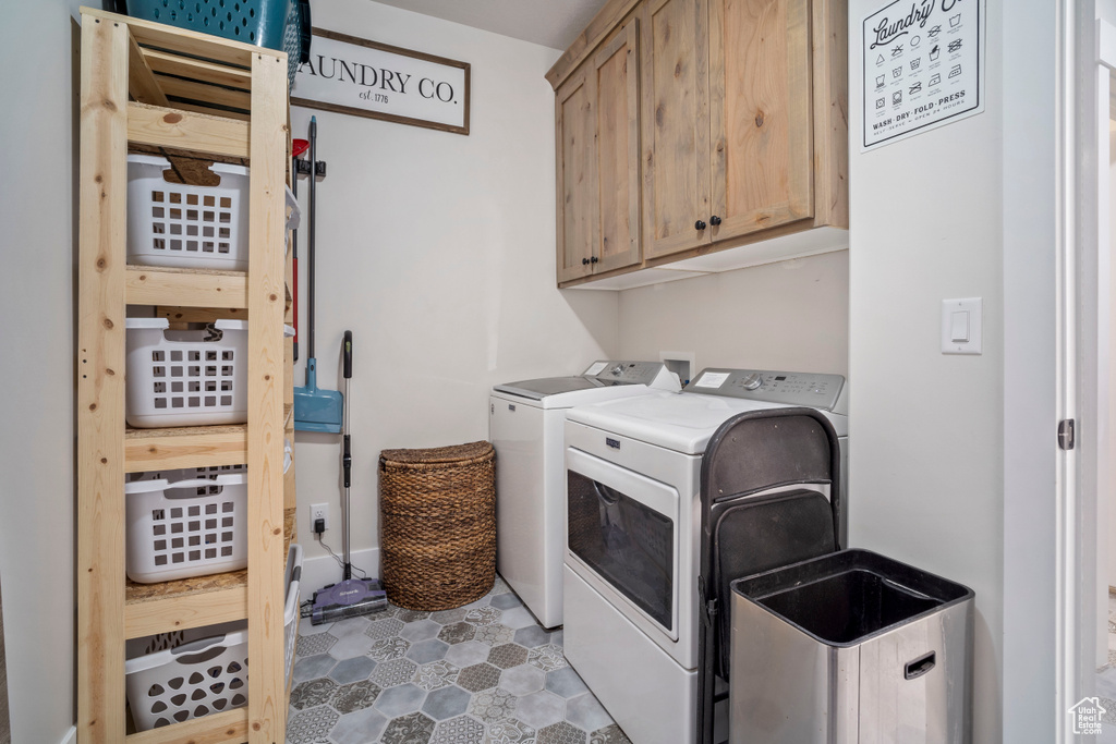 Washroom with cabinet space, separate washer and dryer, and tile patterned flooring