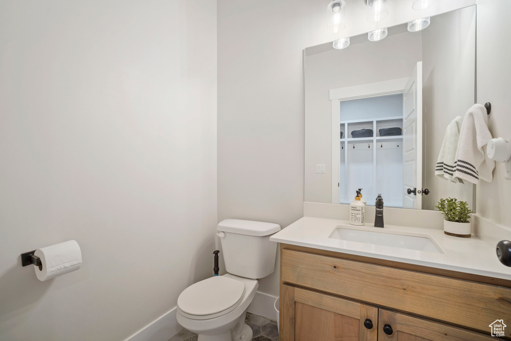 Bathroom featuring toilet, baseboards, and vanity