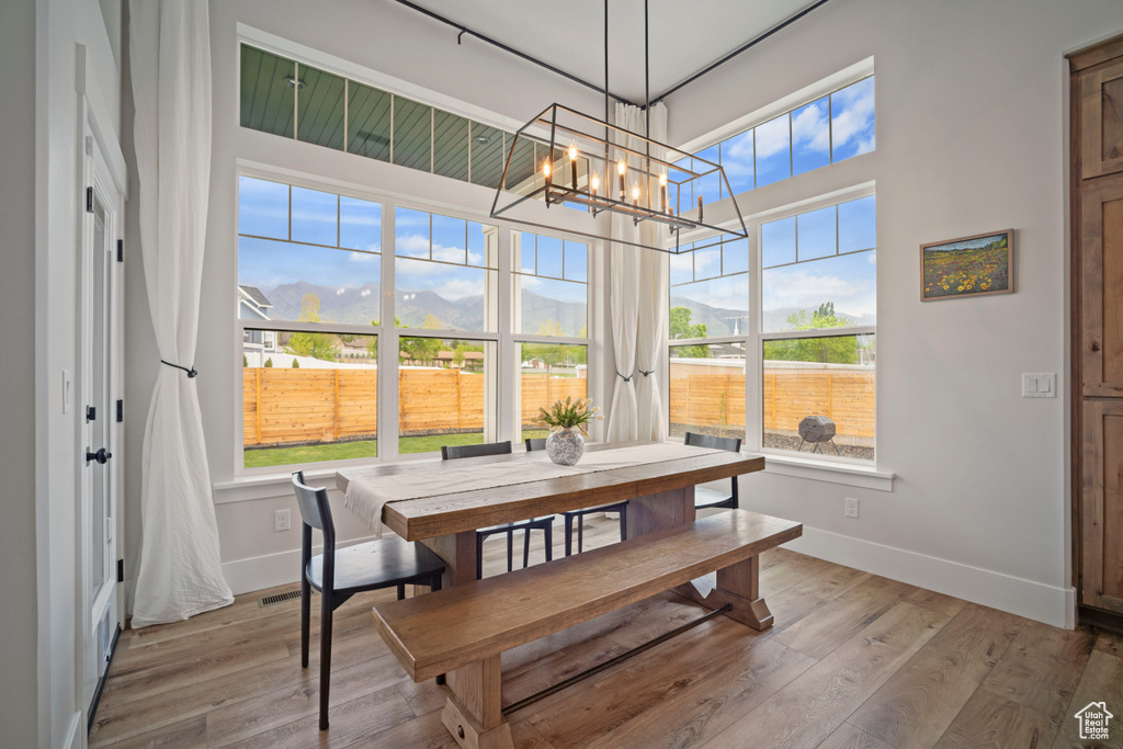 Dining space featuring baseboards, a chandelier, visible vents, and wood finished floors