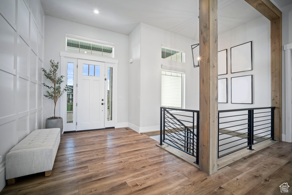 Foyer featuring wood finished floors, baseboards, recessed lighting, and a towering ceiling
