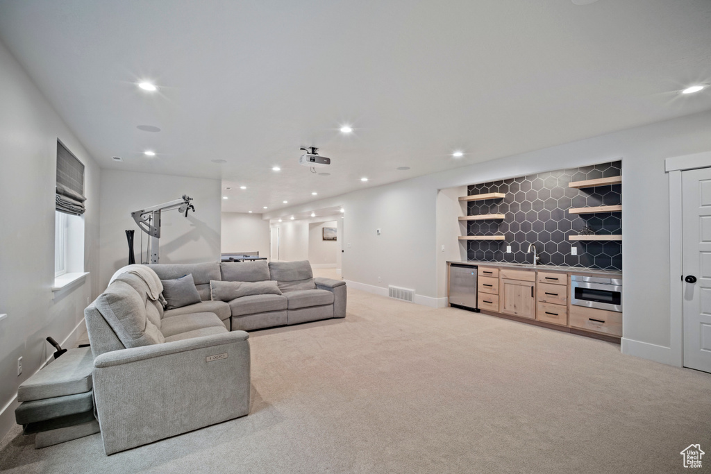 Living area with indoor wet bar, visible vents, baseboards, light colored carpet, and recessed lighting
