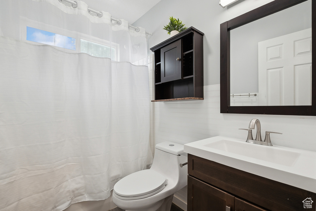 Bathroom featuring vanity, toilet, and a shower with curtain