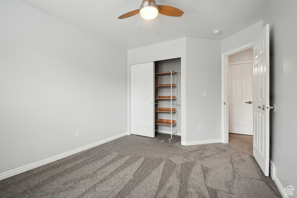 Unfurnished bedroom featuring ceiling fan, carpet flooring, baseboards, and a closet