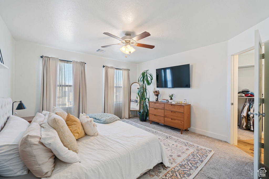 Bedroom featuring visible vents, baseboards, ceiling fan, and light carpet