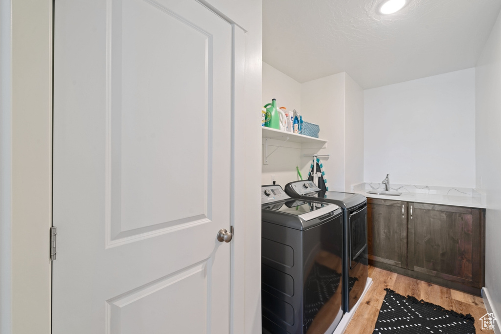 Washroom featuring light wood finished floors and washing machine and dryer