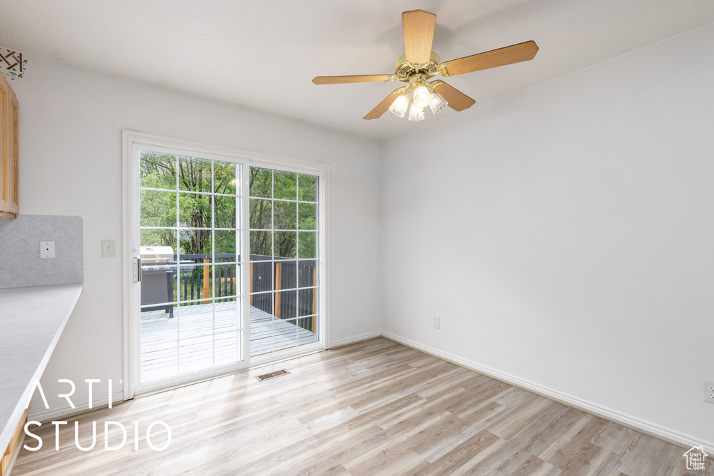 Empty room featuring light wood finished floors, ceiling fan, and baseboards