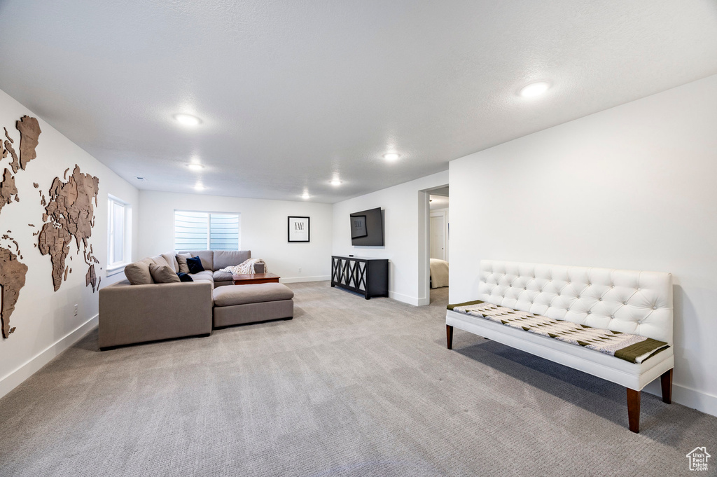 Living room featuring light colored carpet, baseboards, and recessed lighting