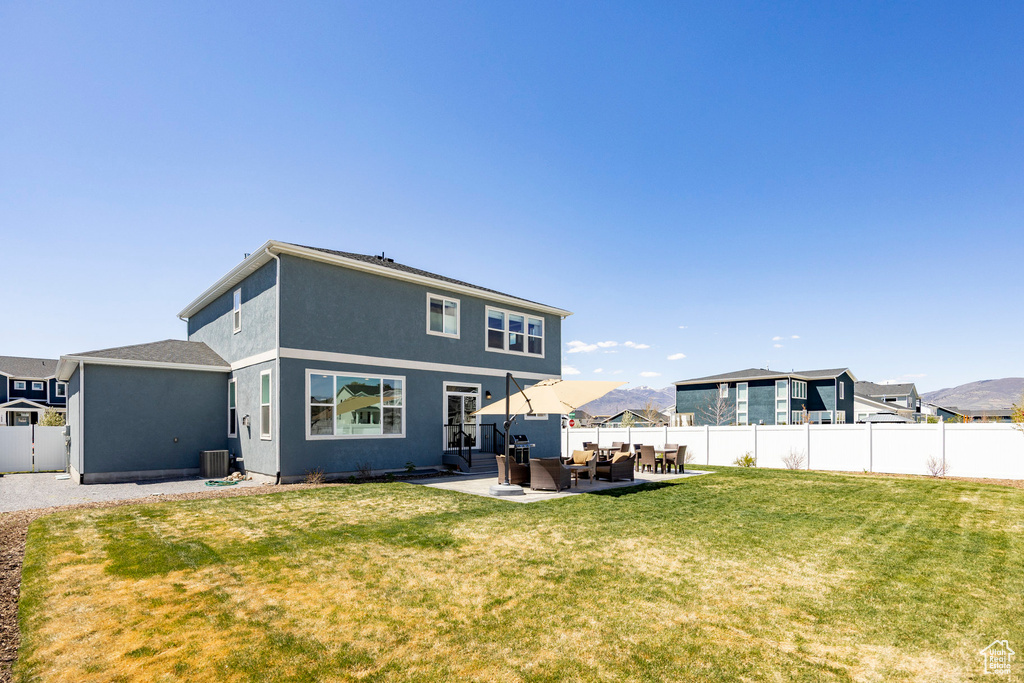 Rear view of house with outdoor lounge area, a patio area, stucco siding, and cooling unit