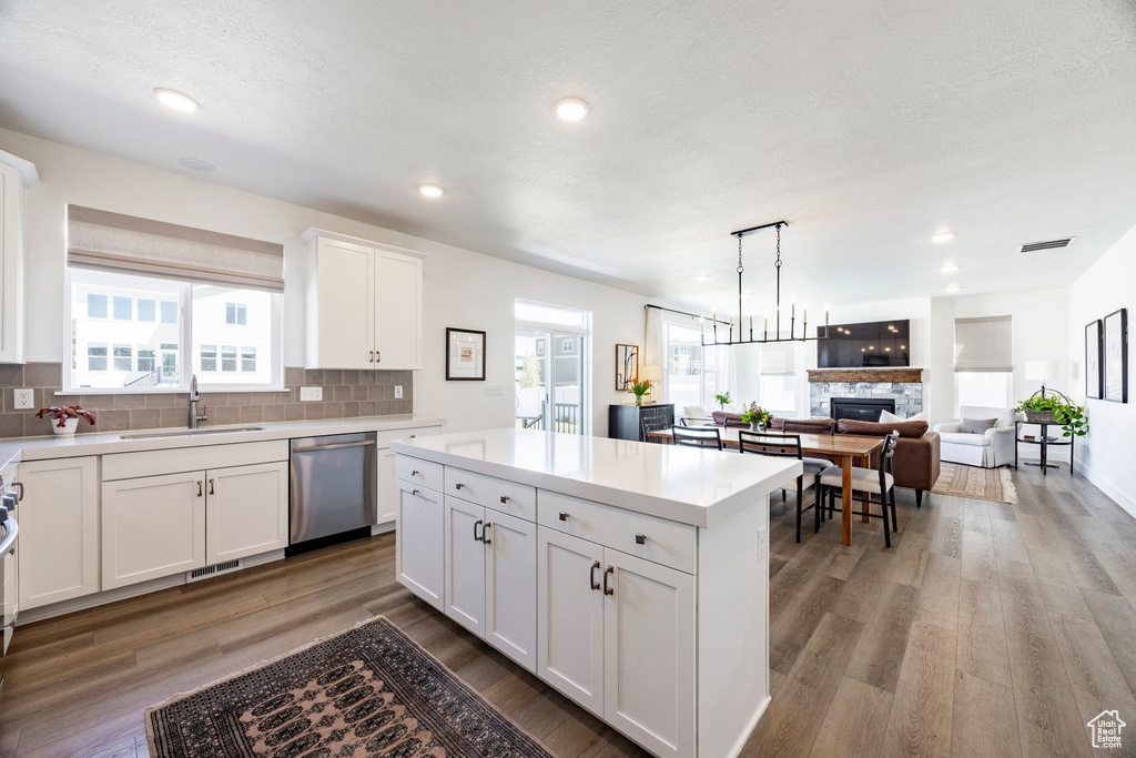 Kitchen with dishwasher, a sink, tasteful backsplash, light countertops, and recessed lighting