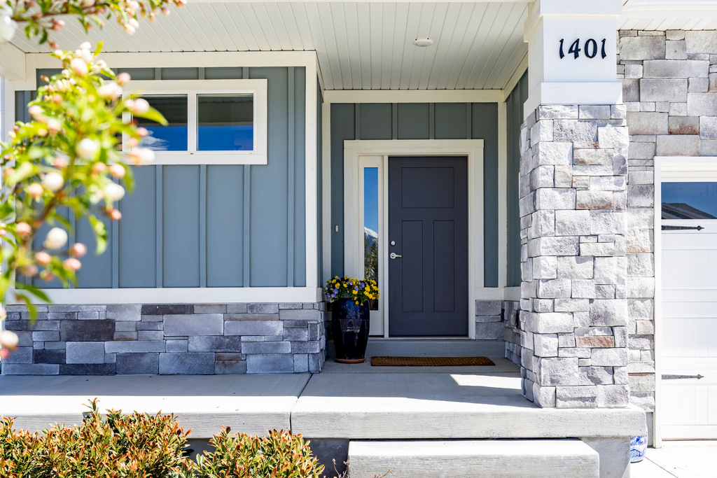 View of exterior entry featuring board and batten siding and stone siding